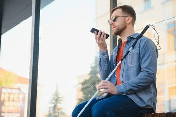 Blinded man waiting for bus at a bus station