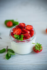Sweet homemade yogurt with fresh ripe strawberries in a glass jar