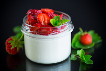 Sweet homemade yogurt with fresh ripe strawberries in a glass jar