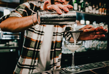 Fototapeta na wymiar man hand bartender making cocktail in glass on bar counter