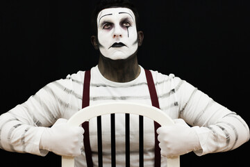 Male mime performing looking up in behind bars with old school style