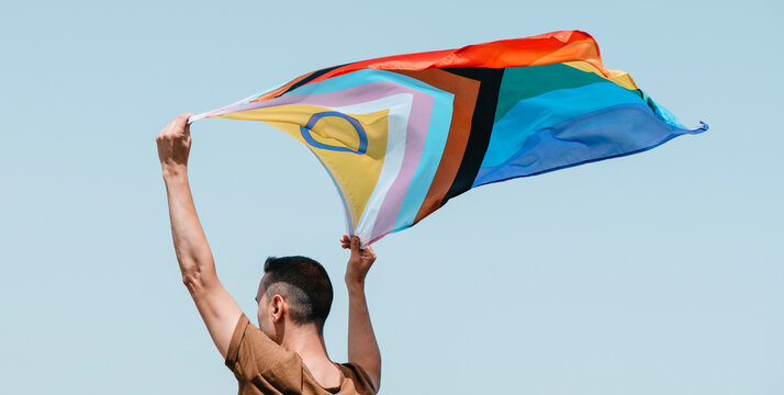waves a progress pride flag, web banner
