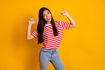 Photo of excited sweet young woman dressed striped outfit pointing thumbs herself isolated yellow color background