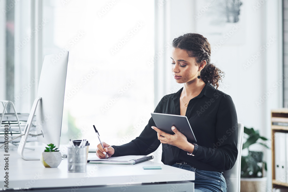 Poster managing her day the smart way. shot of a young businesswoman writing notes while using a digital ta