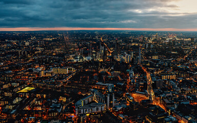 Aerial view of south west London, blue hour just after sunset, orange yellow street lights starting to glow