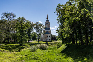 Fototapeta premium summer landscape with ancient churches against the backdrop of a forest and a river on a sunny day