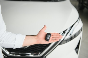 Happy man showing the key of his new car.