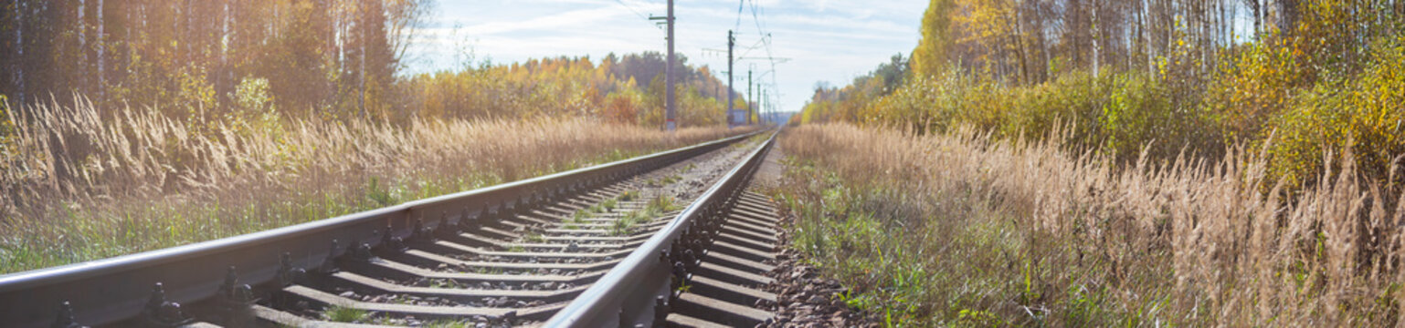 Empty railroad track with blue cloudy sky. Perspective view. Close up. Freight and passenger transportation, industry, business, communications