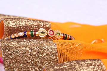 delicately handcrafted minakari stone studded gold bracelet on a golden yellow backdrop