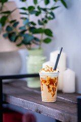 coffee cocktail with whipped cream, caramel, chocolate and ice cubes, in a glass with a cocktail...