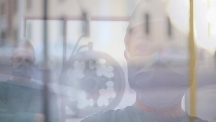 Animation of road traffic over caucasian female surgeon in face mask - Powered by Adobe