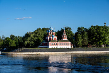 Fototapeta premium summer landscape with ancient churches against the backdrop of a forest and a river on a sunny day