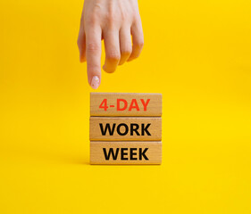 4-day work week symbol. Concept words 4-day work week on wooden blocks. Beautiful yellow background. Businessman hand. Business and 4-day work week concept. Copy space
