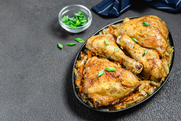 Spicy roasted chicken with vegetables  on dark background. Space for text.