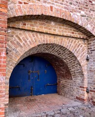 Old round blue wooden door in brick 