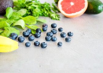 Healthy food: fruit, vegetable, superfood, leaf vegetable on gray concrete background
