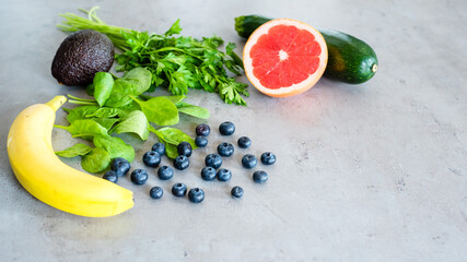 Healthy food: fruit, vegetable, superfood, leaf vegetable on gray concrete background
