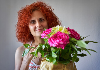Curly redhead lady with a bouquet of roses