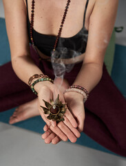 Woman holding burning incense in a yoga class