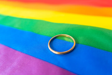 gold wedding ring on the rainbow flag