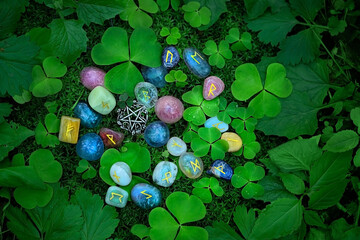 Rune stones with symbols and clover leaves on abstract dark natural background. minerals pebble...