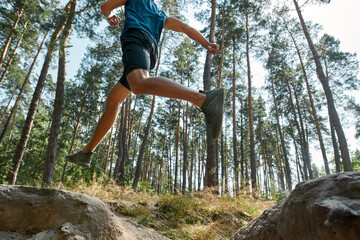 Sportsman jump over hole during run in forest