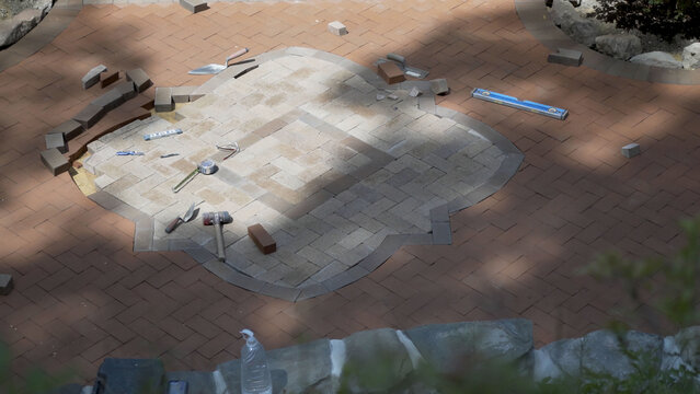 Construction site of custom designed two tone hardscaping brick paver project.
