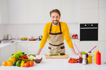 Photo of young cheerful guy cooking meal nutrition cuisine fresh vegetables salad culinary courses indoors