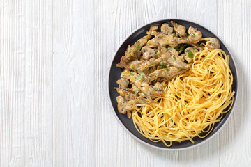liver stroganoff with spaghetti on plate, top view