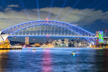 Obraz premium Colourful Light show at night on Sydney Harbour NSW Australia. The bridge illuminated with lasers and neon coloured lights 