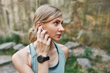 Sports woman choosing music in wireless earphone