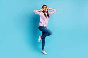 Fototapeta na wymiar Full size photo of young excited woman have fun listen music headphones isolated over blue color background