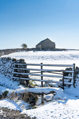 Snow covered field, gate, dry stone wall and barn, Yorkshire Dales in winter - 511328476