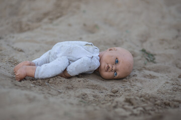 Alone doll thrown on the road. Lonely, sad, broken heart or international missing children's day concept. 