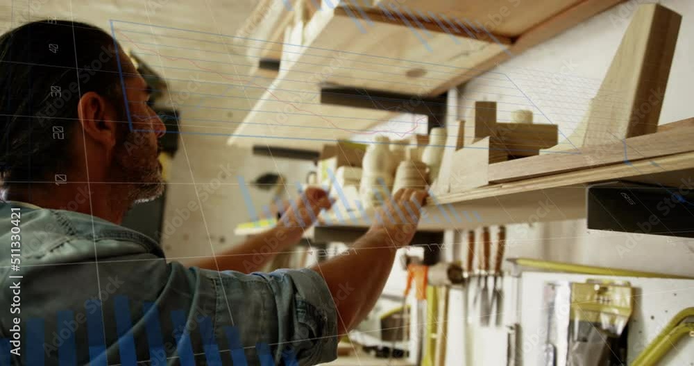 Aufkleber animation of financial graphs over caucasian man searching for tools in carpentry workshop