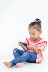 Little girl, sitting with a mobile phone, isolated on white background