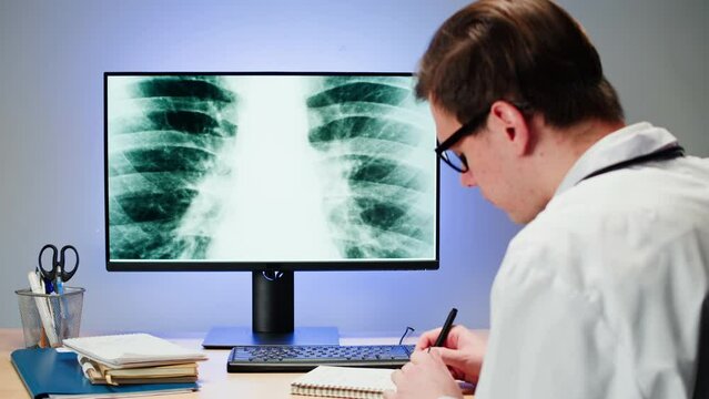 Healthcare and medicine. Doctor examining lungs x-ray close-up. Male therapist looking at ribs roentgen on computer monitor, human chest, checkup. 