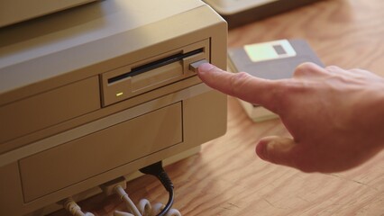 Hand inserting and ejecting Floppy Disk into vintage 80s PC