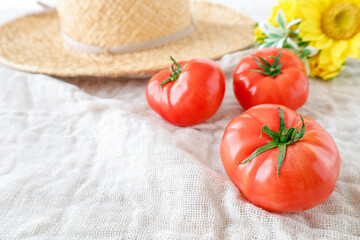 真っ赤なトマトと帽子とひまわりの花　夏のイメージ