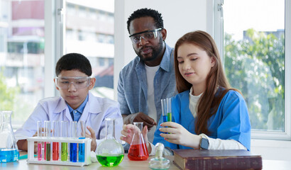 male and female students with various colored liquid glass vials with instructors to advise in the laboratory