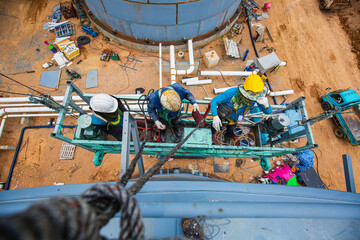 Top view The male worker takes the cable car holding an industrial painting brush used for shell plate tank oil surface color