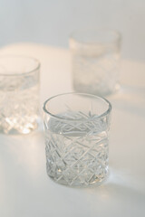 close up view of crystal glass with fresh water on grey blurred background.