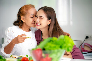 mother and daughter cooking in the kitchen, mother and daughter hugging to love on mother's day, Asian family