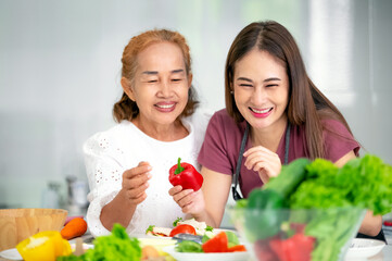 mother and daughter cooking in the kitchen, mother and daughter hugging to love on mother's day, Asian family