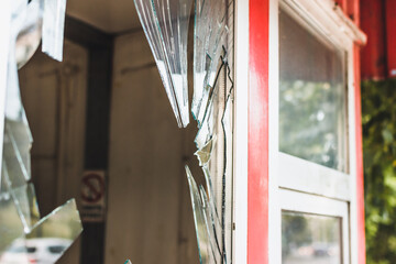Perspective shot of a shattered window of a shop or home - 511335262