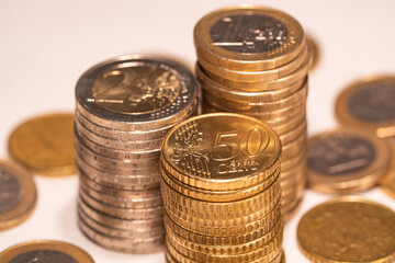 Stacked one euro, two euro and fifty cent coins. European currency.