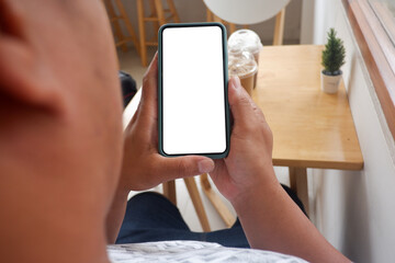 Mockup picture of business woman’s hands holding smart phone with white blank screen in modern place