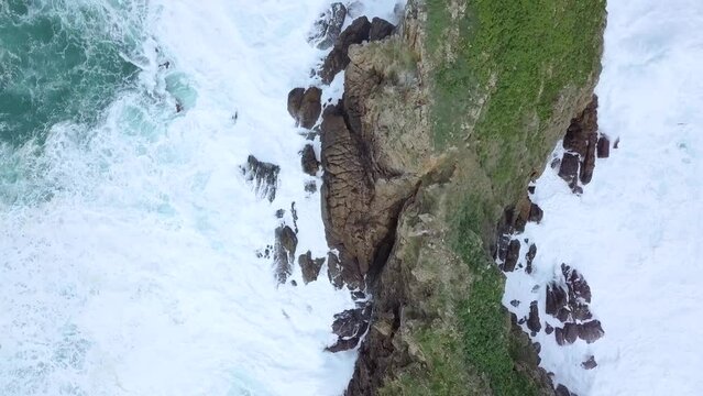 Waves crashing on rocks of ocean shore on Billano Irla island.