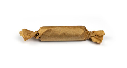 Candy bonbon rolled into craft beige paper. Closeup chocolate candy dessert wrapped in cardboard...