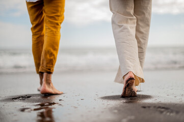 Young couple feet while walking on a beach